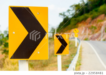 Yellow caution danger sign from a curved road 22958481