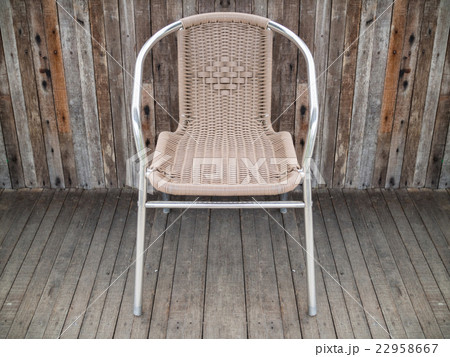 Metal chair with woven seat on old wooden floor 22958667