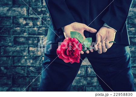 バラの花を持っているスーツの男性の写真素材