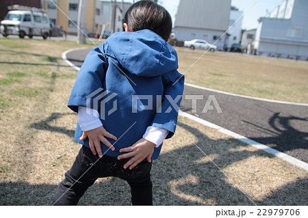 公園でお尻を両手で押さえるオムツが取れていない男の子 22979706