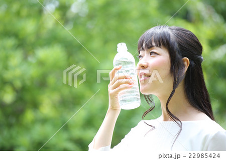 新緑の中で水を飲む女性 22985424