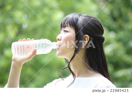 新緑の中で水を飲む女性 22985425