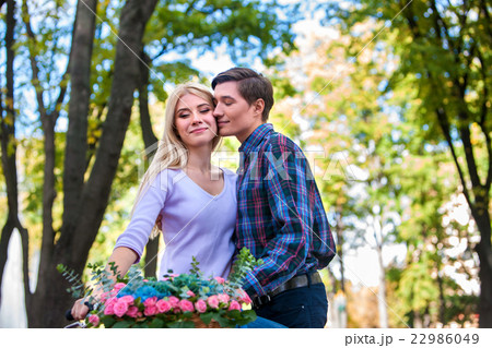 Young beautiful couple with flowers basket kissing 22986049