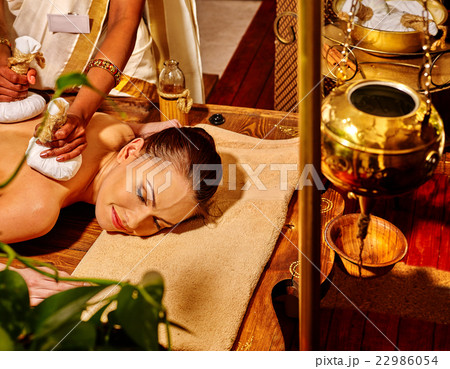 Woman having massage with pouch of rice. 22986054