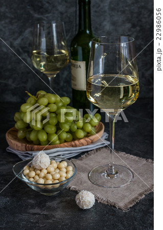 Bottle of white wine, two glasses and bunch of 22986056