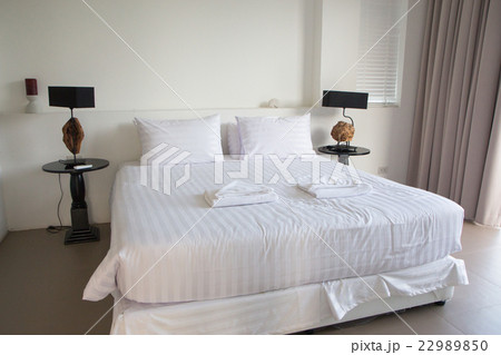 white king size bed, two pillows,lamp in bedroom 22989850