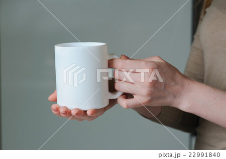 White cup in hand of a girl 22991840