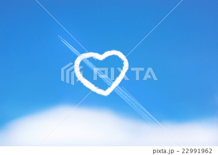 ハートの形をした雲と飛行機雲の写真素材