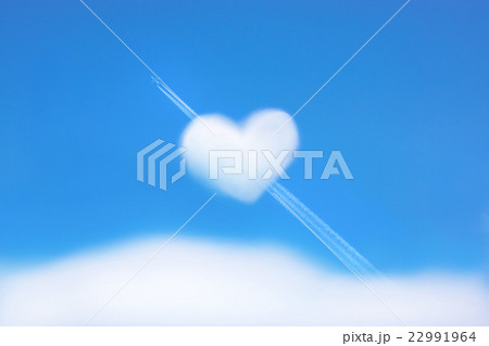 ハートの形をした雲と飛行機雲の写真素材