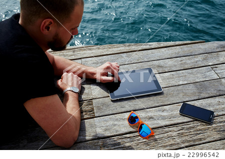 Man is searching information on touch pad Man is searching information on touch pad 22996542