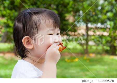 Closeup little asian girl enjoy eating her lunch Closeup little asian girl enjoy eating her lunch 22999576