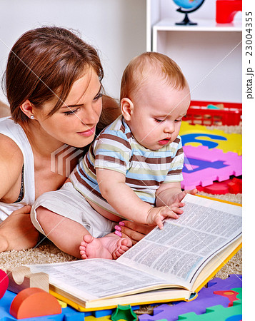 Kid with mother baby boy on floor and read book. Kid with mother baby boy on floor and read book. 23004355