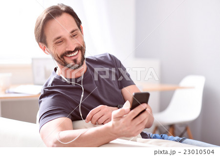 Man using earphones and looking at phone 23010504