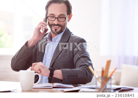 Man looking at watch while speaking Man looking at watch while speaking 23010845