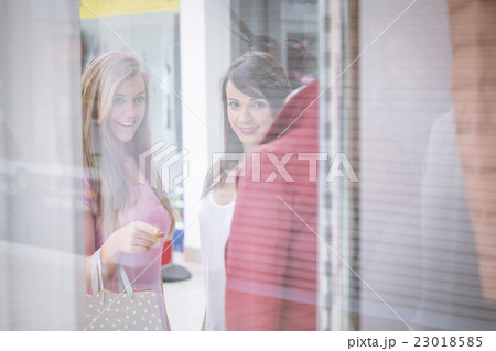 Two beautiful women window shopping in mall Two beautiful women window shopping in mall 23018585