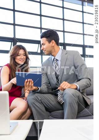 Businessman and businesswoman using digital tablet 23019816