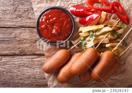 Corn dogs, french fries, pepper and ketchup Corn dogs, french fries, pepper and ketchup 23026147