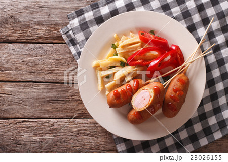 Corn dog with fries and vegetables on a plate Corn dog with fries and vegetables on a plate 23026155