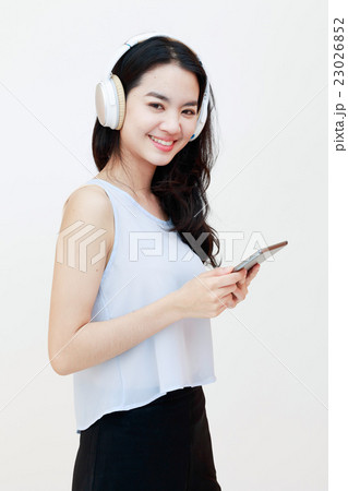 Young pretty lady with tablet and headphones isolated on white Young pretty lady with tablet and headphones isolated on white 23026852