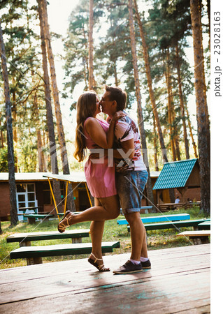Romantic young couple kissing on background forest Romantic young couple kissing on background forest 23028163