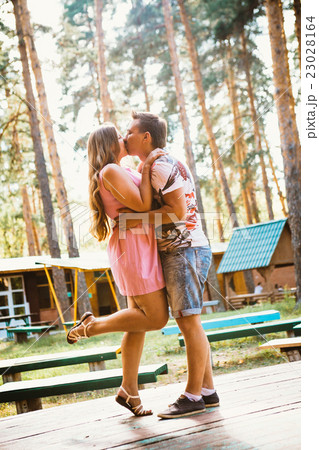 Romantic young couple kissing on background forest Romantic young couple kissing on background forest 23028164