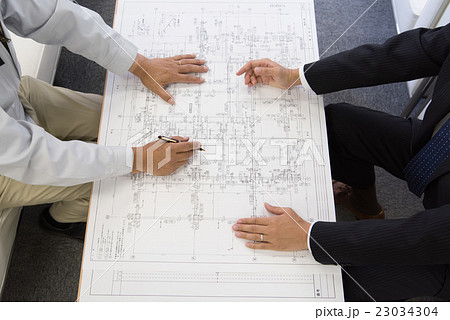 図面打ち合わせをするビジネスマンと作業員 図面打ち合わせをするビジネスマンと作業員 23034304