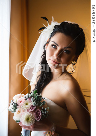 beautiful young happy  bride standing near window 23036791