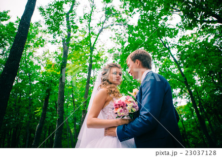 young couple posing in park on background trees young couple posing in park on background trees 23037128