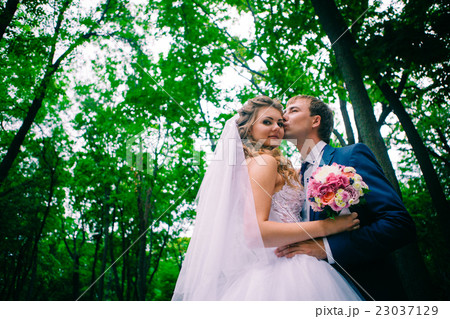young couple posing in park on background trees young couple posing in park on background trees 23037129