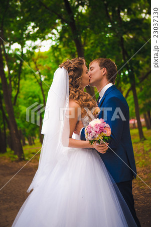 young couple posing in park on background trees young couple posing in park on background trees 23037130
