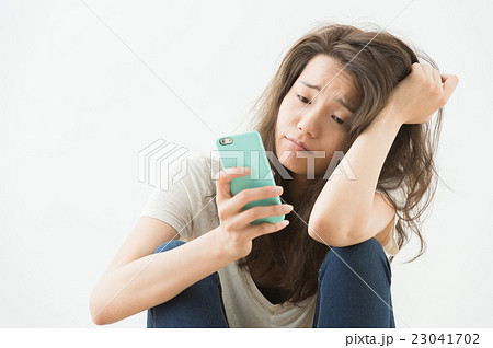 スマホを持つ女性(ネガティブイメージ) スマホを持つ女性(ネガティブイメージ) 23041702