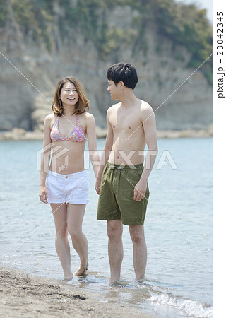波打ち際にたたずむカップル 23042345