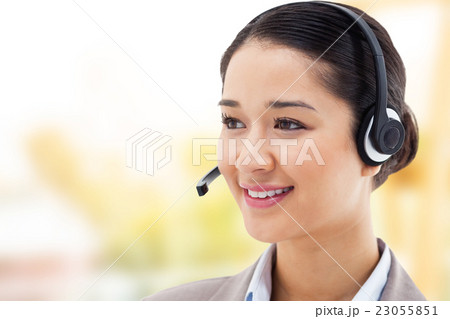 Composite image of happy operator posing with a headset Composite image of happy operator posing with a headset 23055851