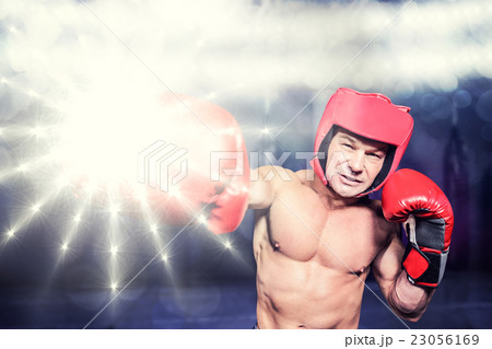 Composite image of boxer punching against black background 23056169