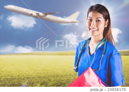 Composite image of asian nurse with stethoscope looking at the c 23056170