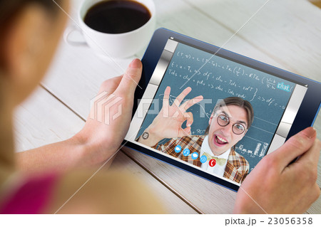 Composite image of woman using tablet pc 23056358