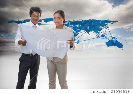 Composite image of estate agent looking at blueprint with potent Composite image of estate agent looking at blueprint with potent 23056618