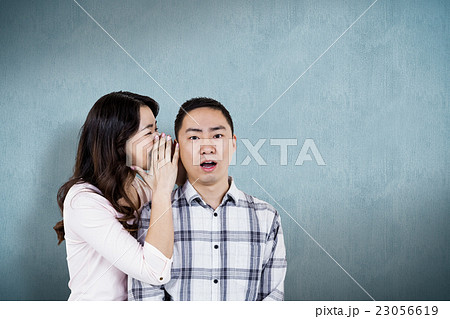 Composite image of woman whispering secret to husband Composite image of woman whispering secret to husband 23056619