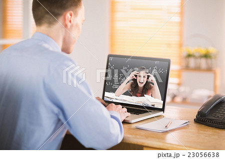 Composite image of businessman working on his laptop Composite image of businessman working on his laptop 23056638