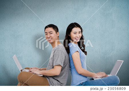 Composite image of portrait of young happy couple using laptop w Composite image of portrait of young happy couple using laptop w 23056809