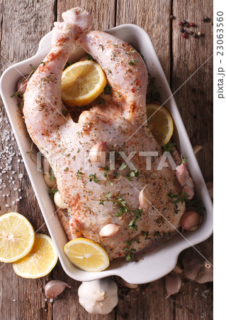 raw whole chicken marinated with garlic, thyme 23063560