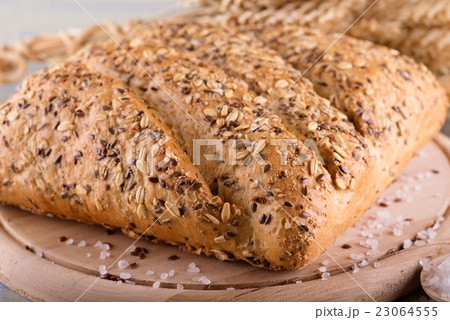 Loaf of cereal bread on wooden board with salt Loaf of cereal bread on wooden board with salt 23064555