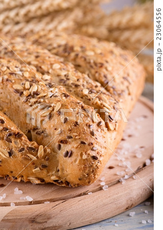 Loaf of multicereal bread on wooden board Loaf of multicereal bread on wooden board 23064556