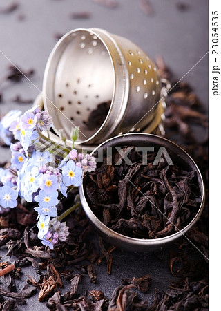 Strainer full of dry tea leaves with blue flower Strainer full of dry tea leaves with blue flower 23064636