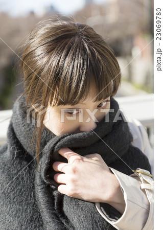 女性　冬　寒い　風　ストール　巻く　風邪　表情　外　見つめる 23069780