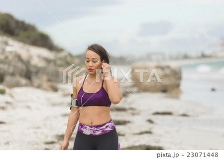 Female runner preparing for outdoor workout on the Female runner preparing for outdoor workout on the 23071448