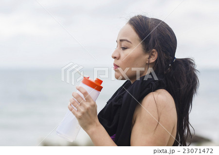 Beautiful fitness athlete woman resting drinking Beautiful fitness athlete woman resting drinking 23071472