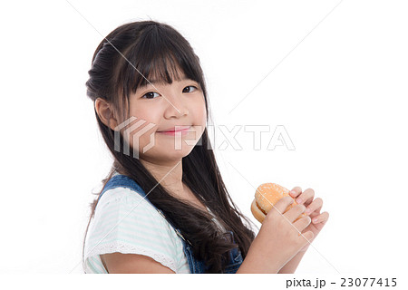 Beautiful asian girl eating hamburger 23077415