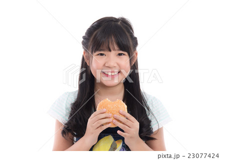 Beautiful asian girl eating hamburger Beautiful asian girl eating hamburger 23077424