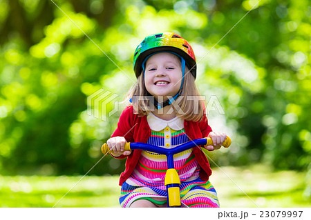 Little girl riding a tricycle Little girl riding a tricycle 23079997